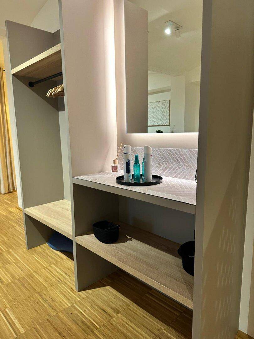 Praktischer Einbauschrank mit Spiegel und Ablageflächen im Flurbereich, bietet Stauraum und Funktionalität.