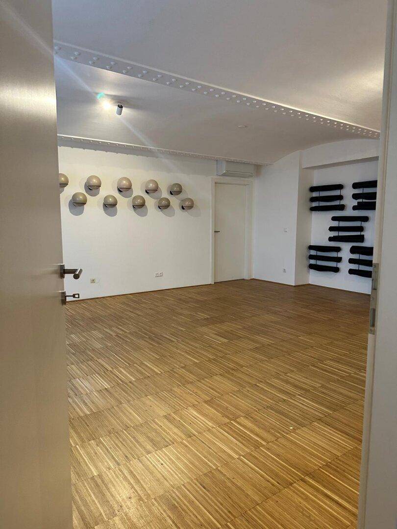 Heller und geräumiger Gewerberaum mit Parkettboden und dekorativer Decke, bietet vielseitige Nutzungsmöglichkeiten.