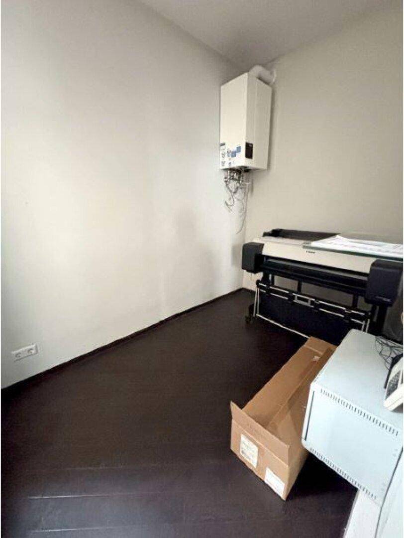Kleiner Raum mit Wandheizung und großem Drucker, ideal als Abstell- oder Technikraum.