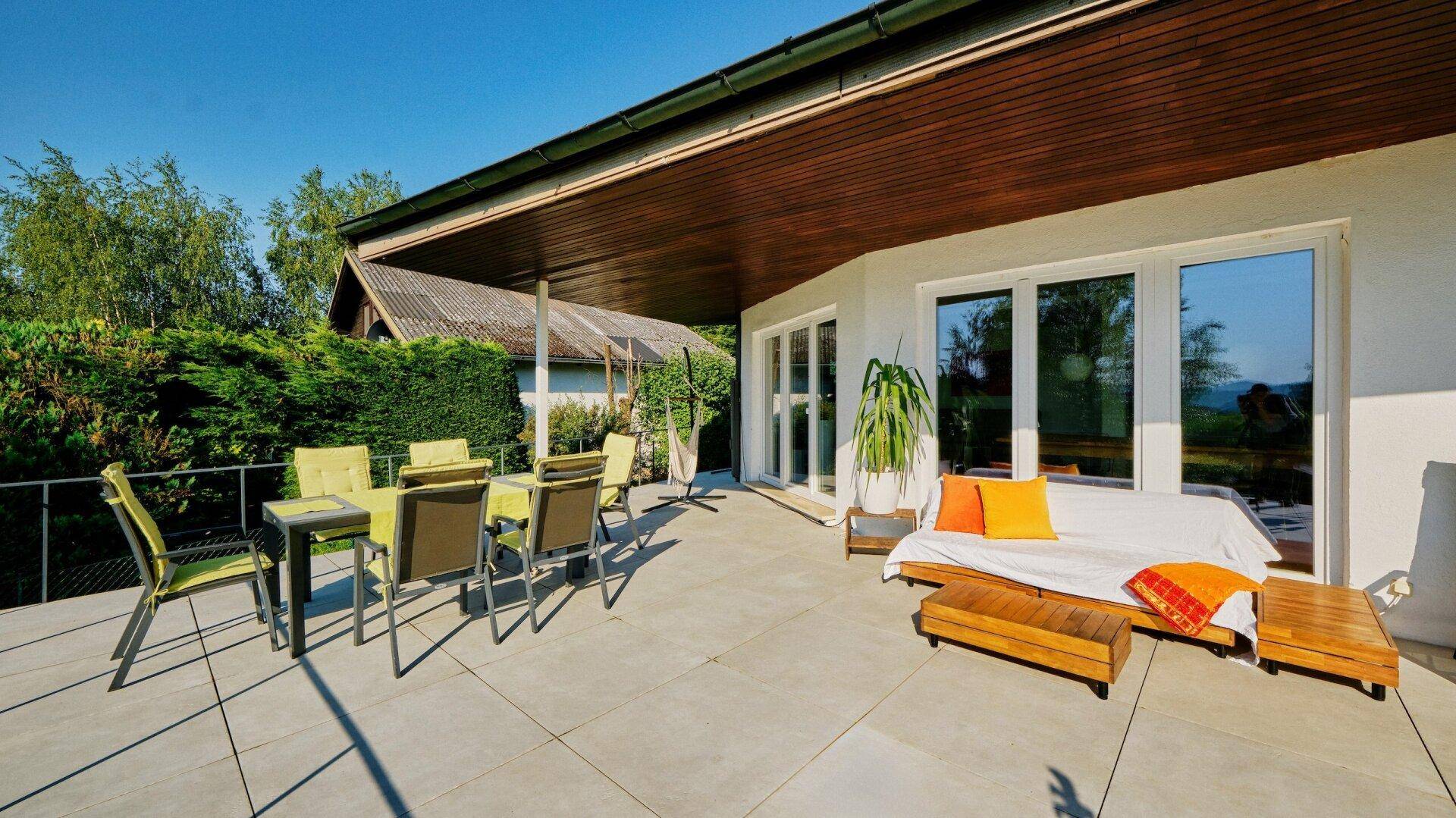 Geräumige Terrasse mit Essbereich, Lounge-Möbeln und Holzdach für entspannte Stunden im Freien.