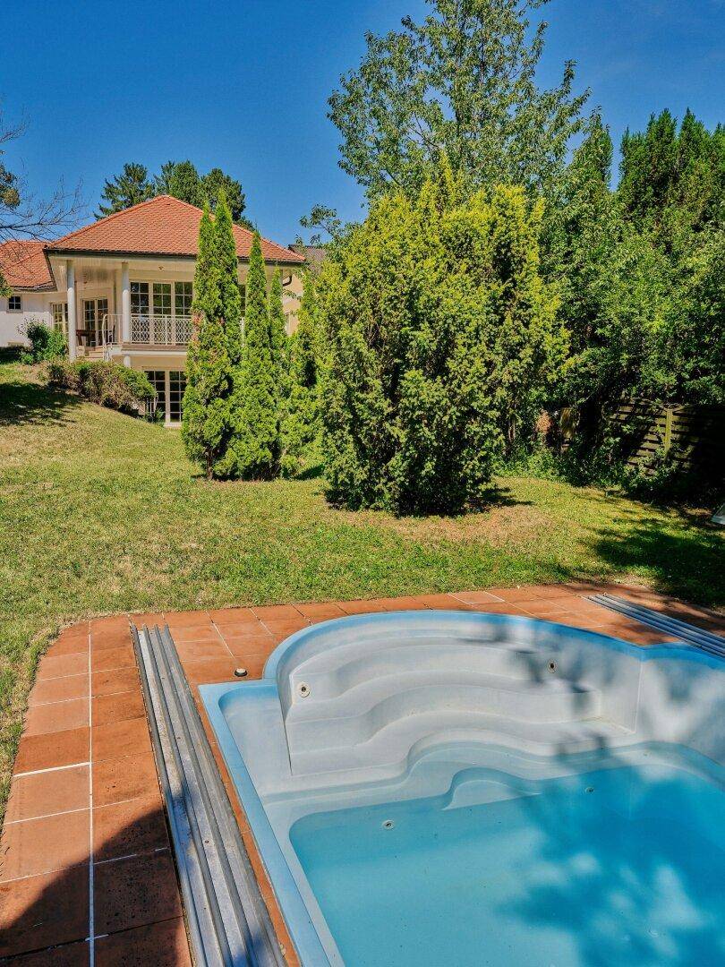 Der Pool im Garten bietet eine erfrischende Abkühlung mit Blick auf das Wohnhaus im Hintergrund.