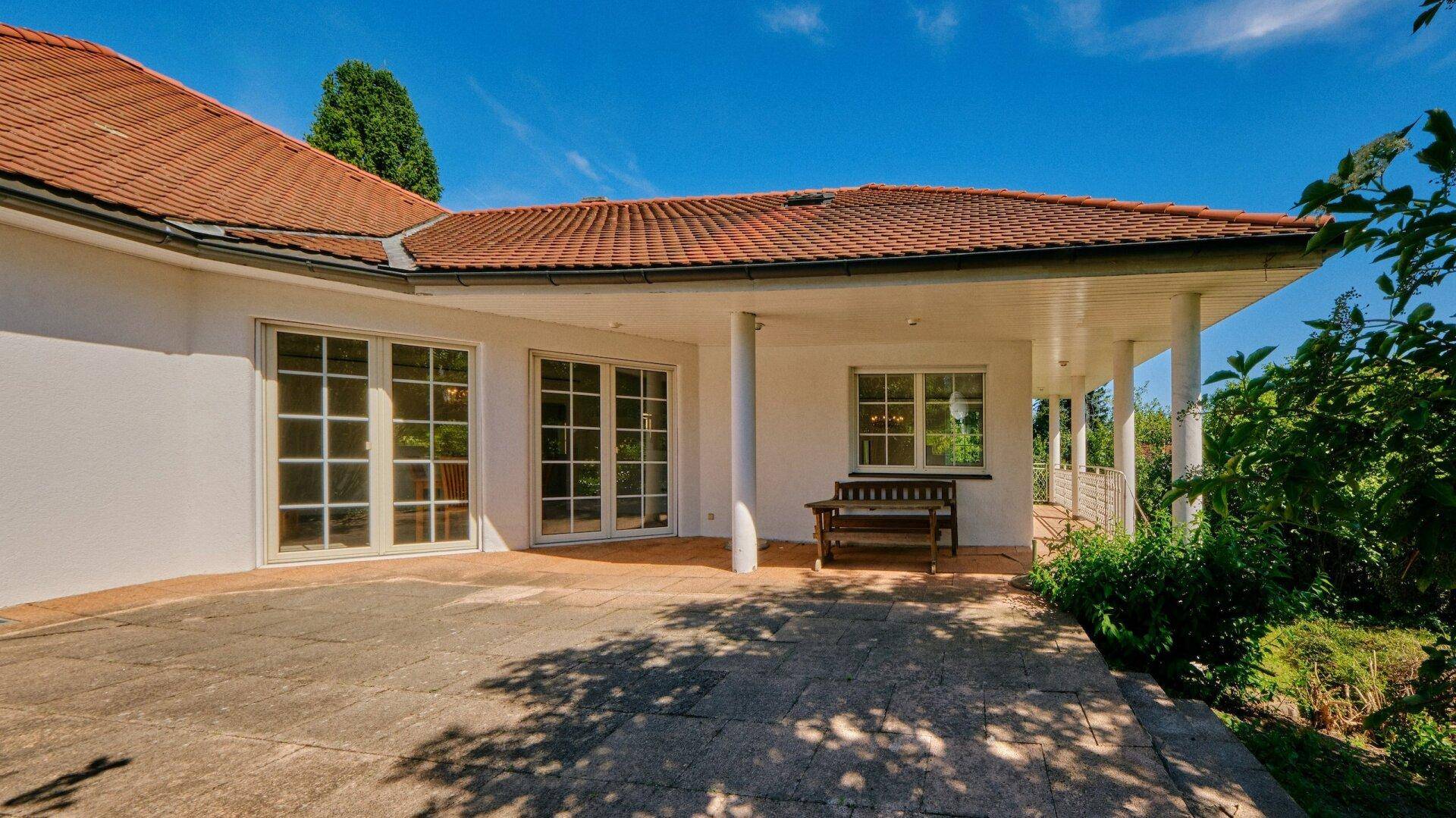 Geräumige, gepflasterte Terrasse mit Sitzbank und direktem Zugang zu den Innenräumen des Hauses.