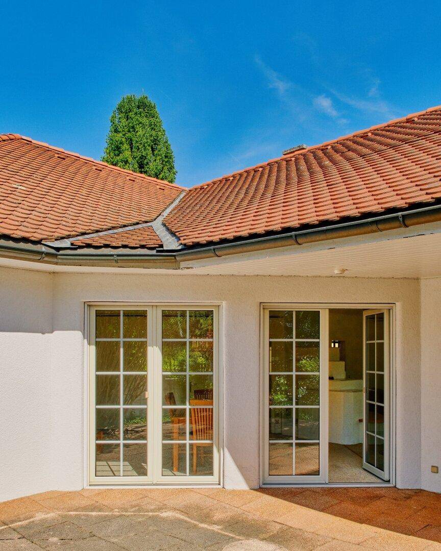 Zugang zur Terrasse durch große Fenstertüren, die viel natürliches Licht in die Räume lassen.