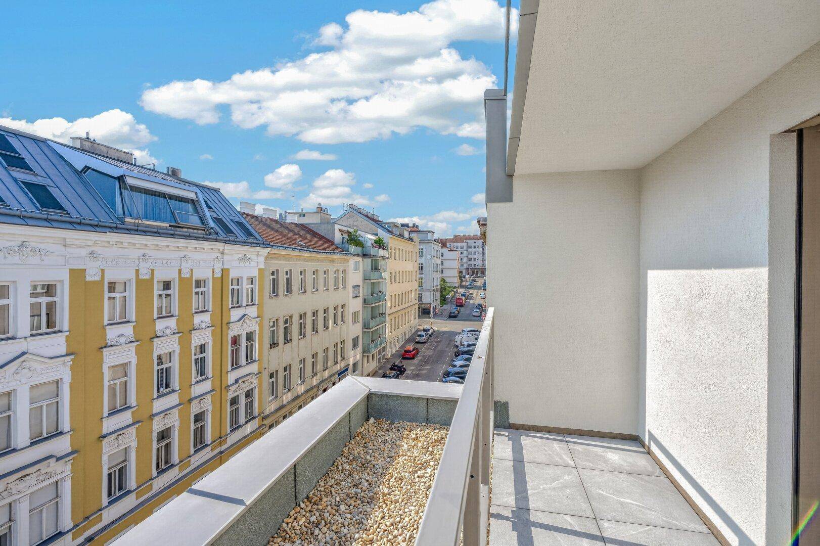 Schmaler Balkon mit Fliesen und Kiesdekor, ideal für sonnige Stunden mit Blick auf die Straße.