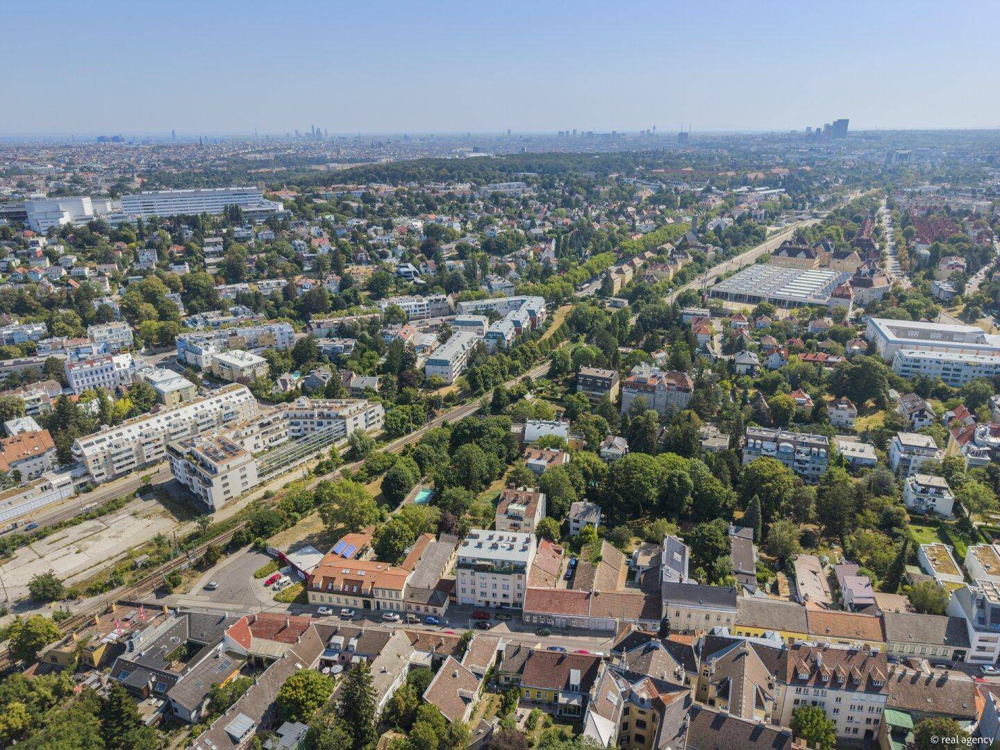 Ausgedehnte Luftaufnahme einer städtischen Umgebung mit Wohngebäuden und Infrastruktur.