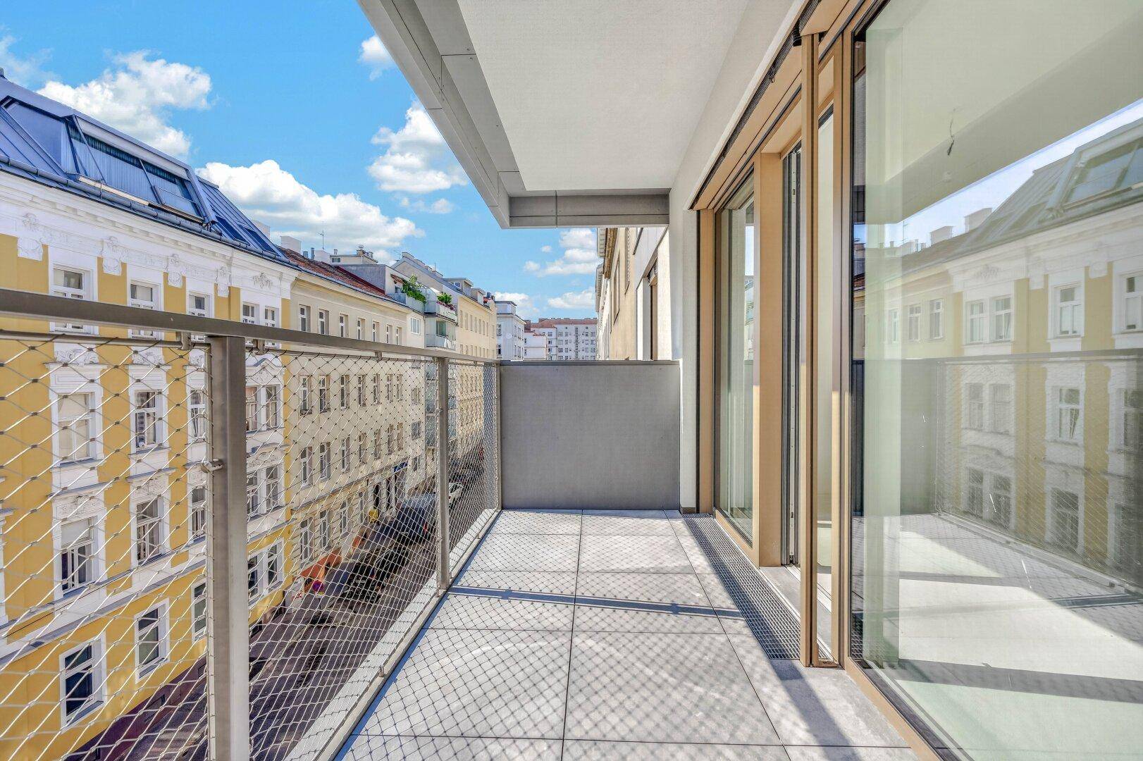 Geräumiger Balkon mit Fliesenboden und weitem Blick über die städtische Umgebung.