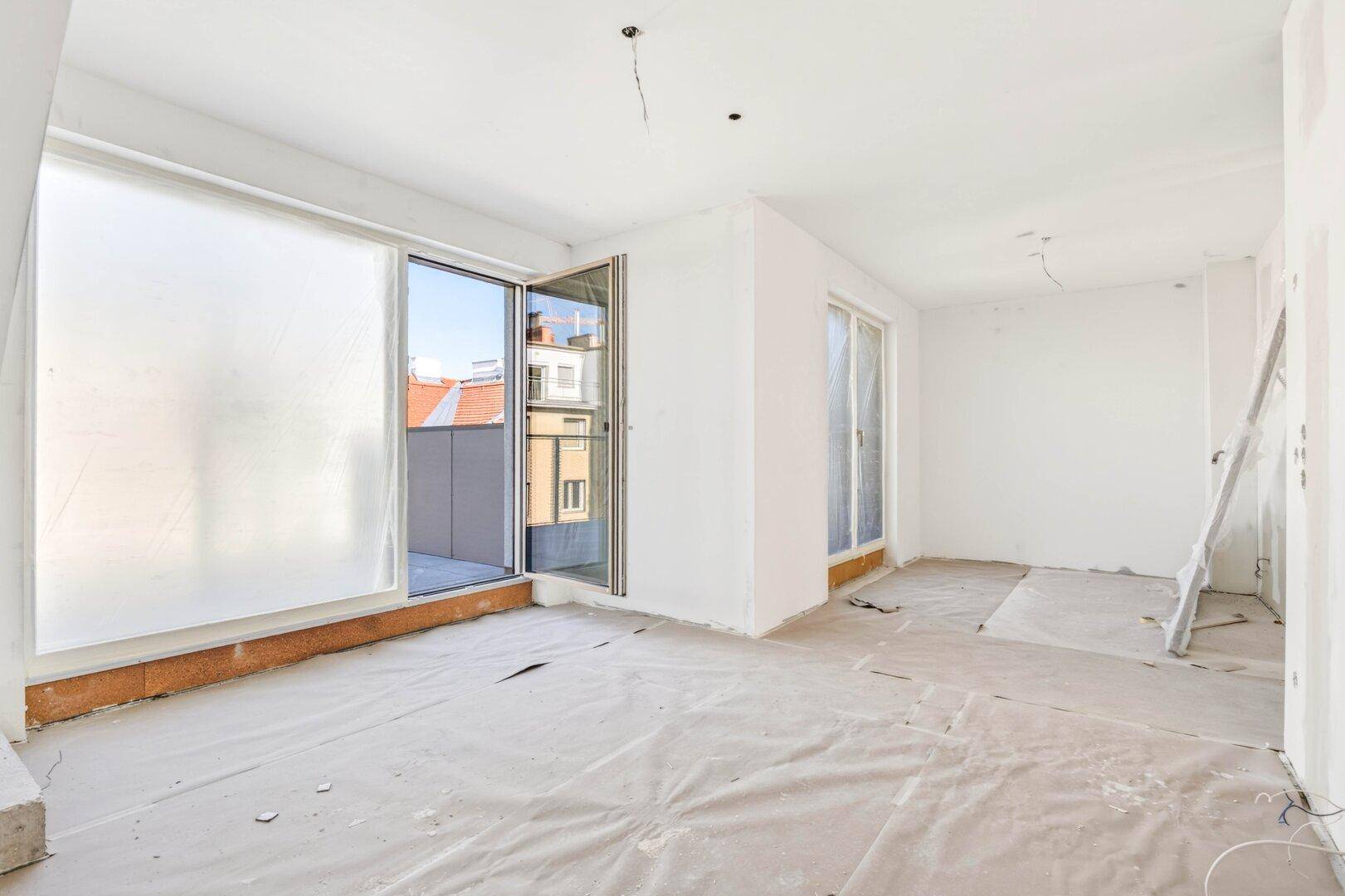 Helles Rohbauzimmer mit zwei großen Schiebetüren, bietet Zugang zu Außenbereichen.