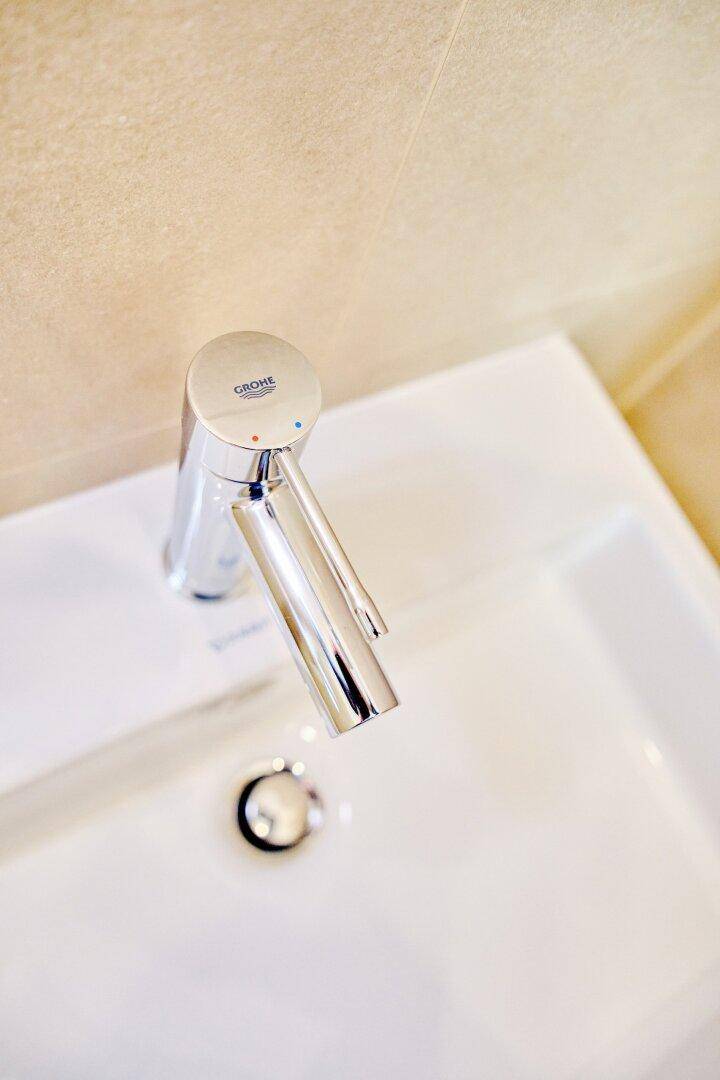 Hochwertige Chromarmatur der Marke Grohe auf einem weißen Waschbecken, glänzend und modern.
