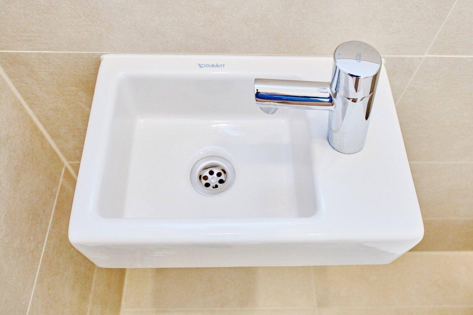 Kleines, modernes Waschbecken der Marke Duravit mit Chromarmatur, ideal für ein Gäste-WC.