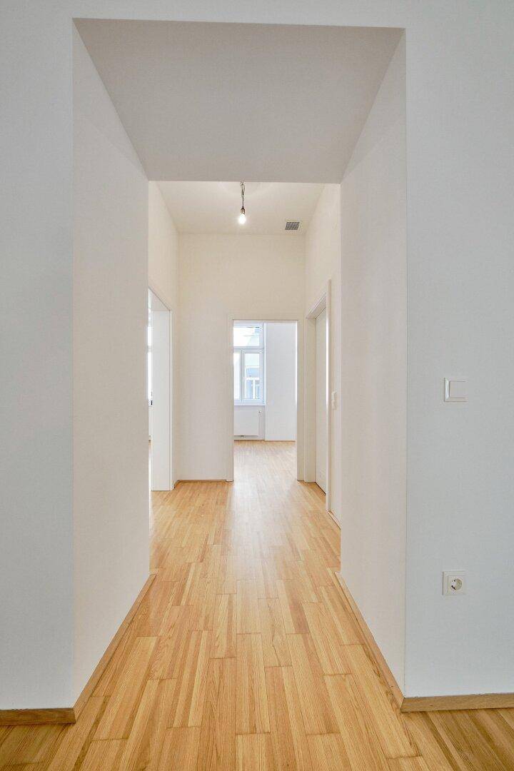 Heller Flur mit Parkettboden, der zu verschiedenen Zimmern der Wohnung führt.
