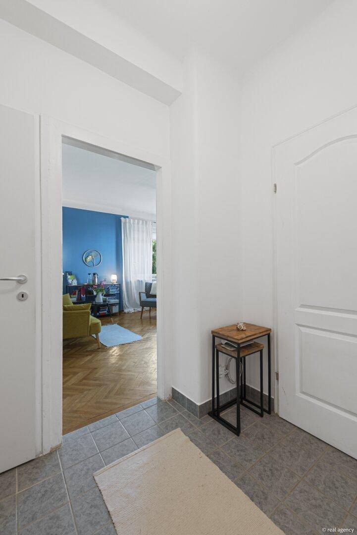 Eingangsbereich mit Fliesenboden und offenem Durchgang zum angrenzenden Wohnzimmer.