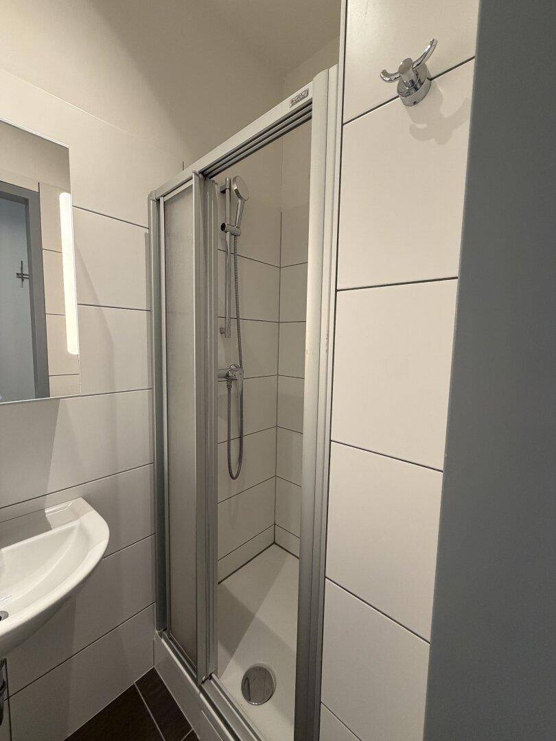 Duschbereich im Badezimmer mit Glasabtrennung und modernen Armaturen.
