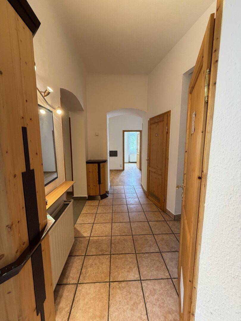 Geräumiger Flur mit Fliesenboden und traditionellen Holztüren, der zu anderen Zimmern führt.