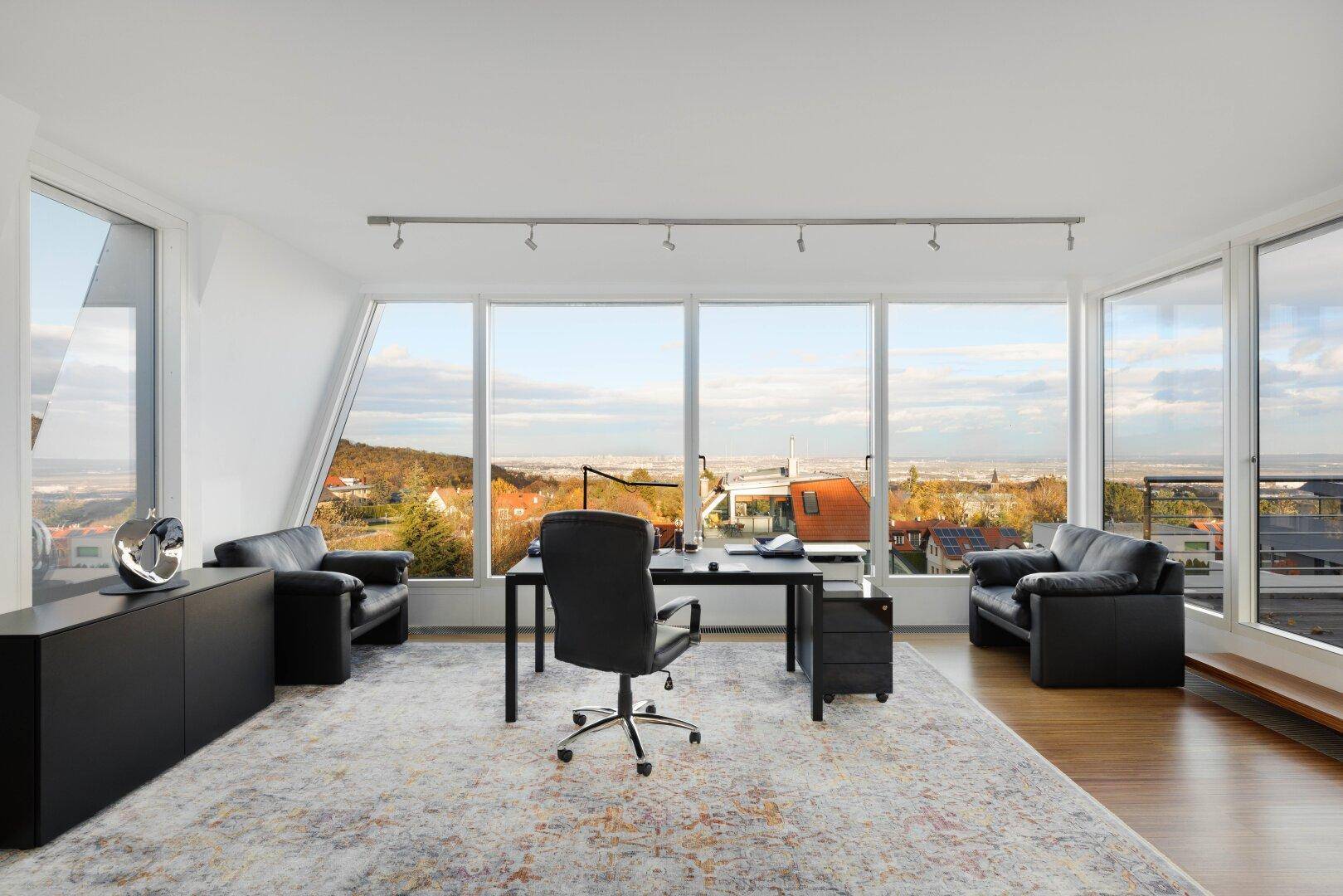 Helles Büro mit großen Panoramafenstern und weitem Blick über die Stadt und Landschaft.