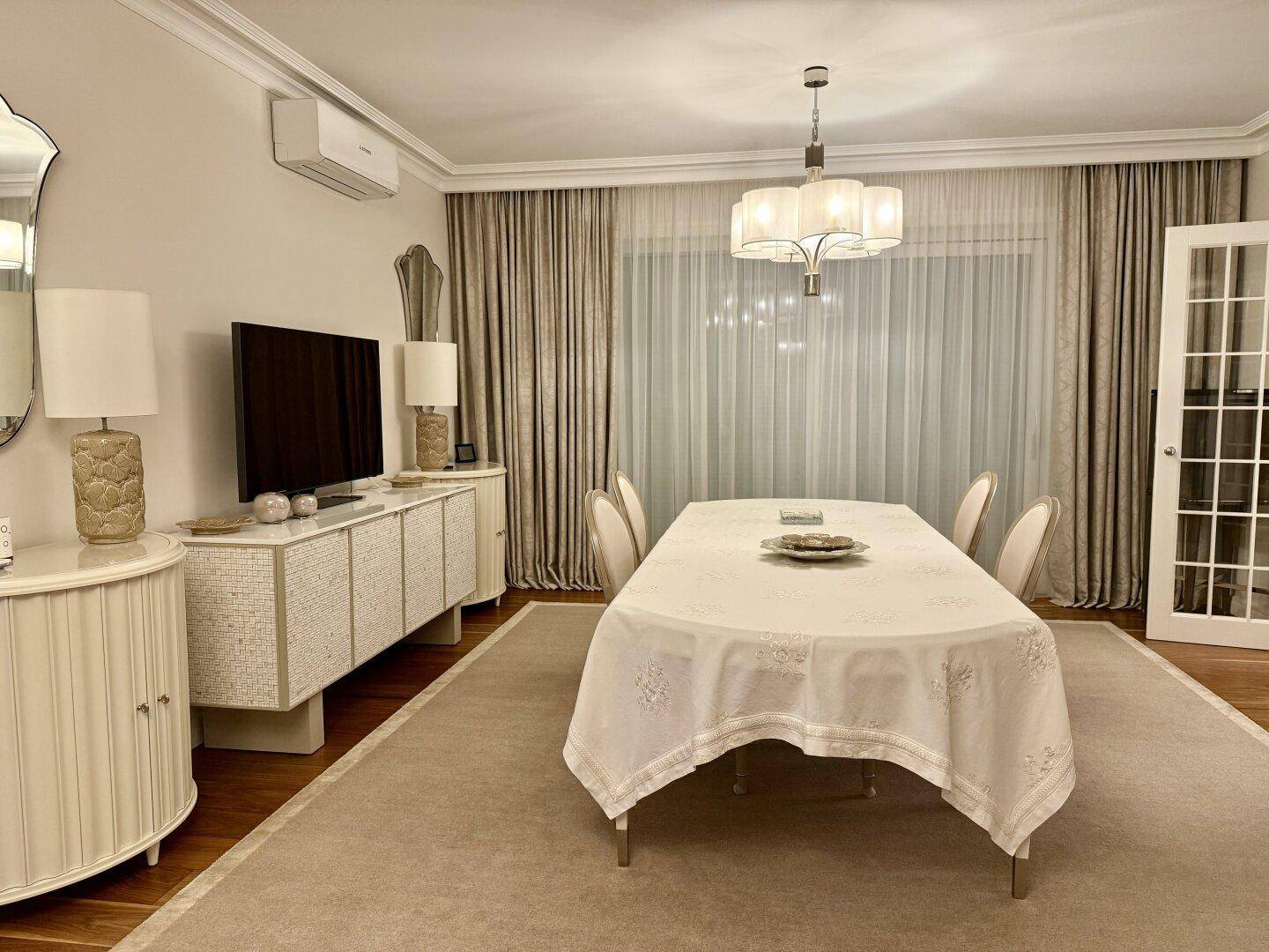 Geräumiger Essbereich mit gedecktem Tisch, eleganten Stühlen und Zugang zu einem anderen Raum.