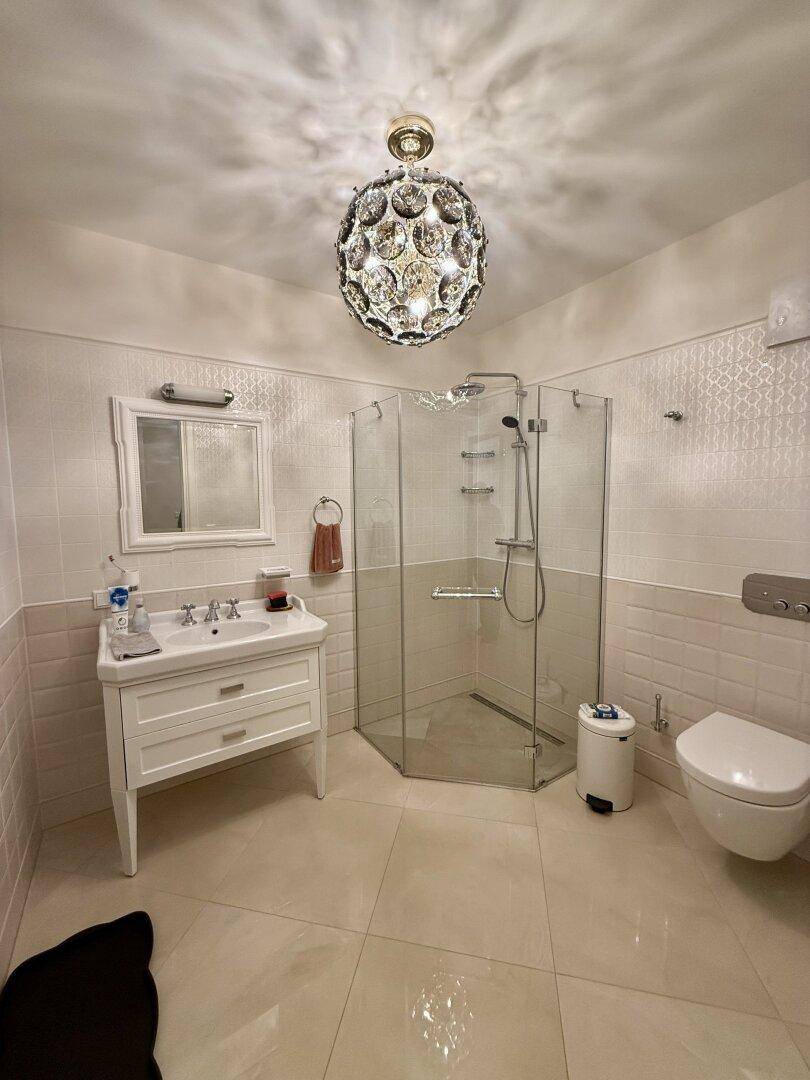 Modernes Badezimmer mit Duschkabine, Waschbecken und Wand-WC.
