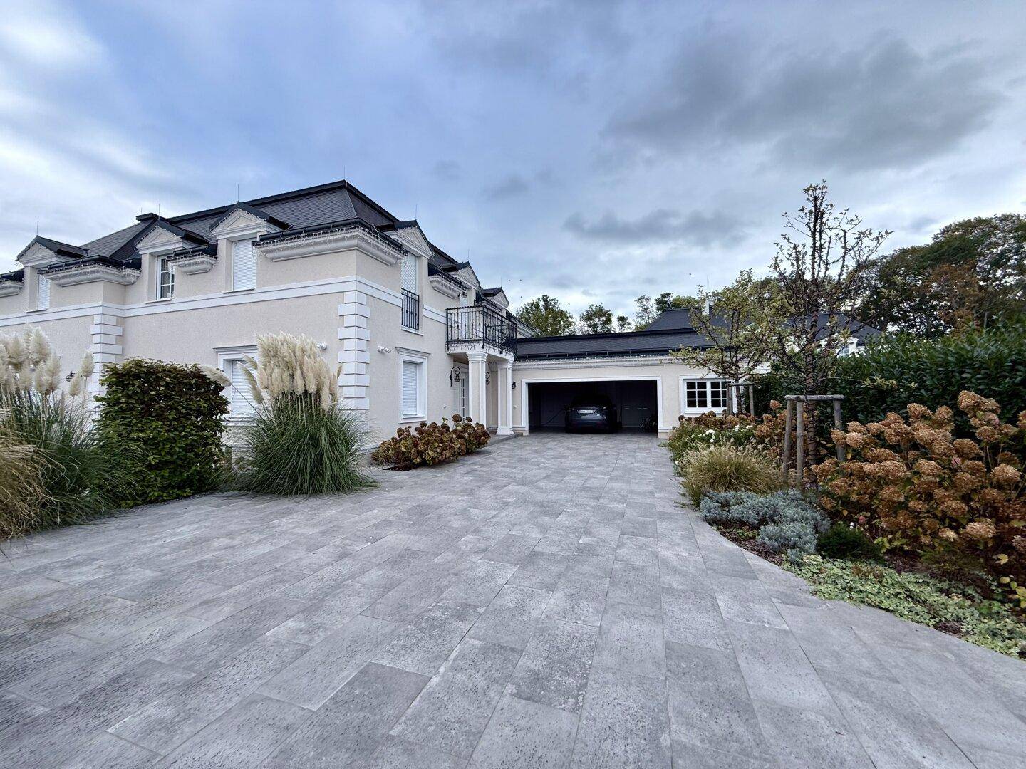 Elegante Villa mit gepflasterter Auffahrt und integrierter Garage.