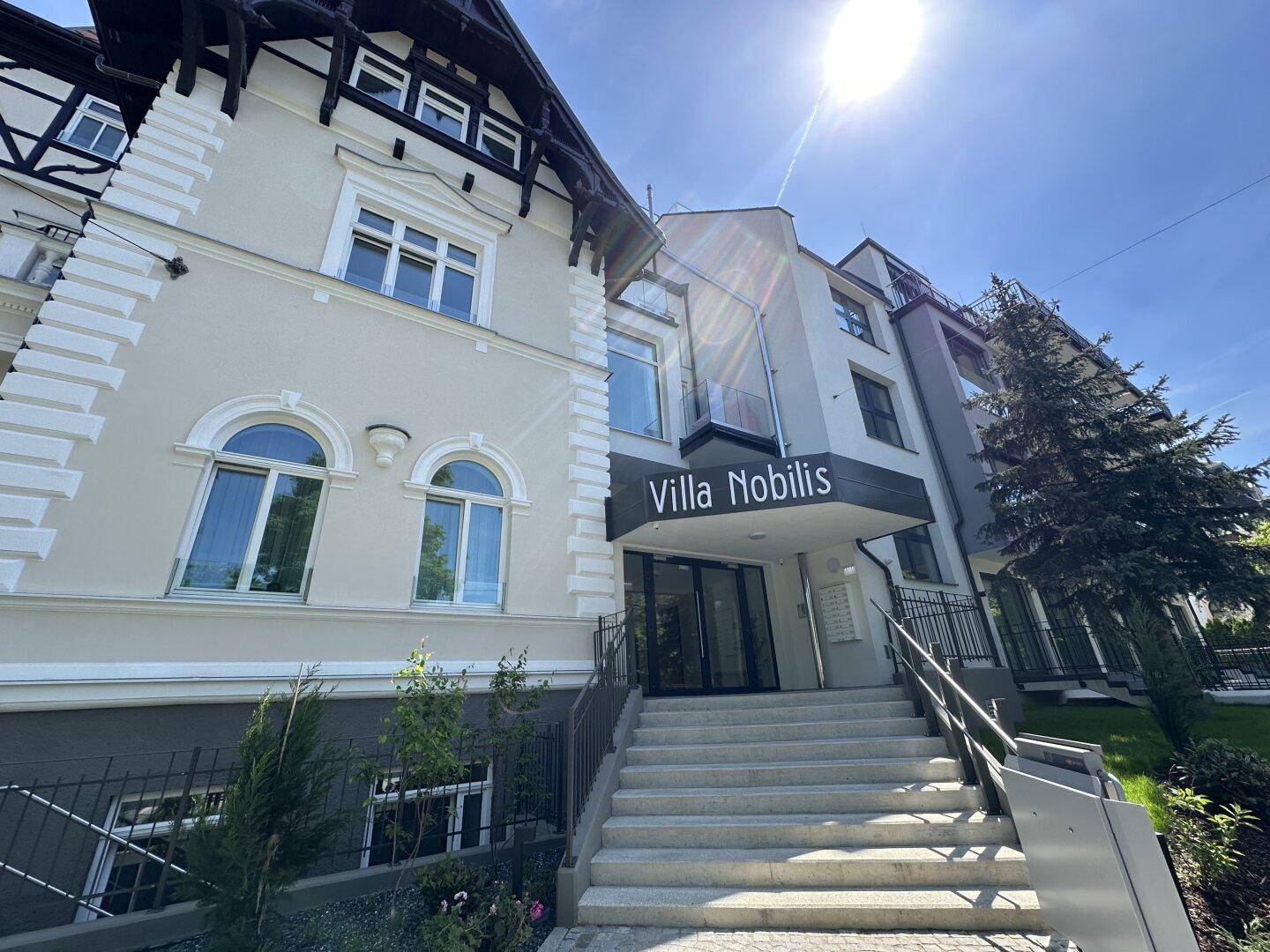 Haupteingang der Villa Nobilis mit breiter Treppe und moderner Fassadengestaltung.