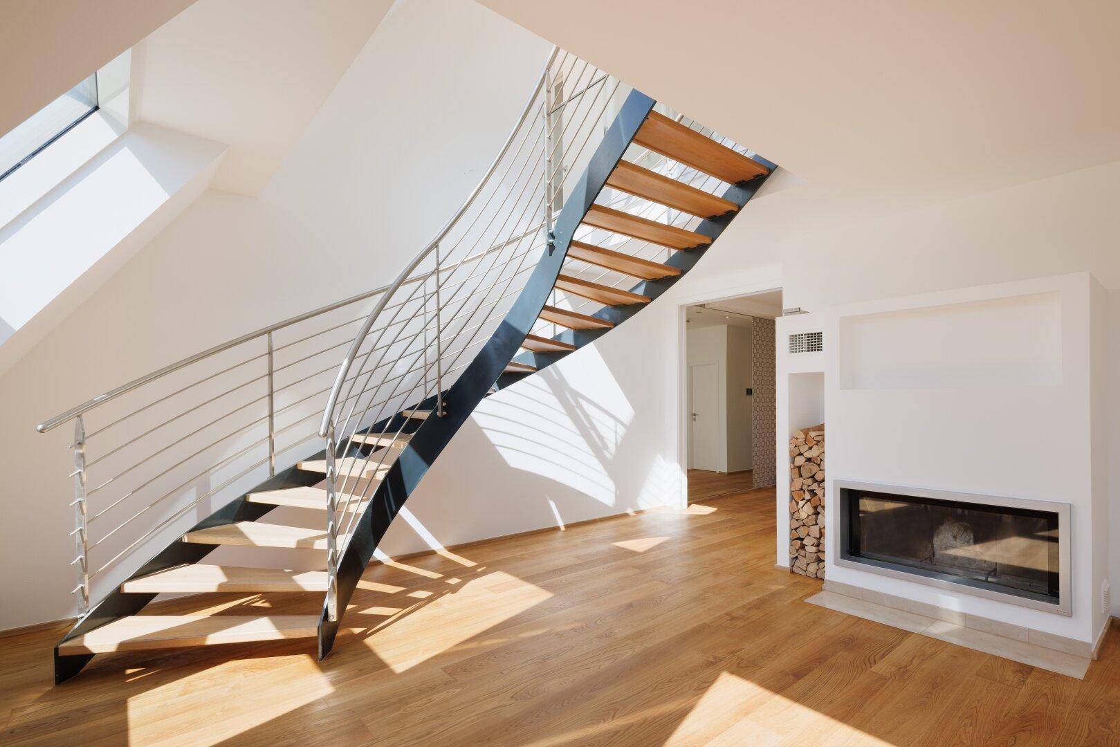 Geräumiges Wohnzimmer mit moderner Wendeltreppe, Kamin und viel Tageslicht.
