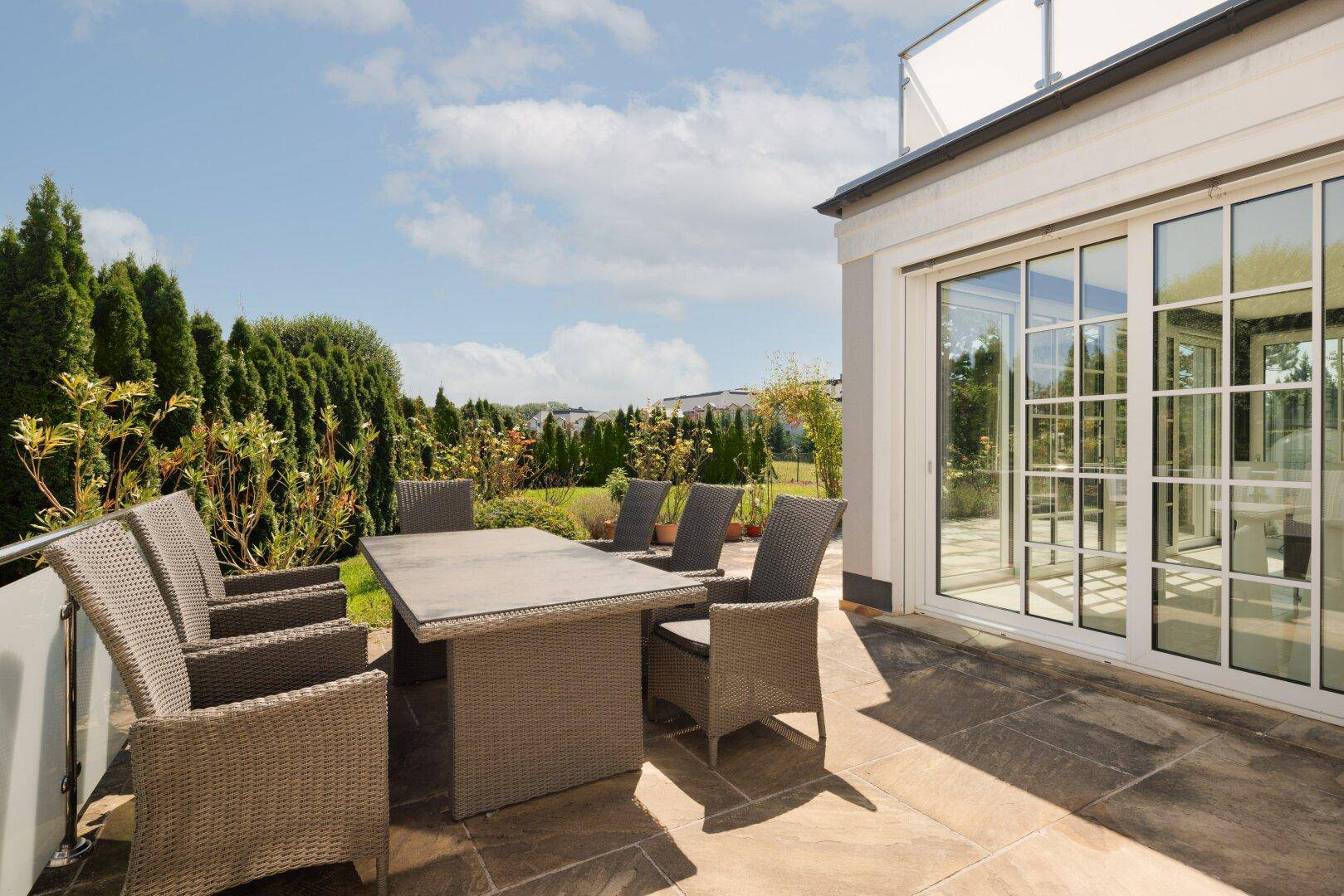 Geräumige Terrasse mit Outdoor-Sitzbereich und Blick ins Grüne, ideal für entspannte Stunden im Freien.