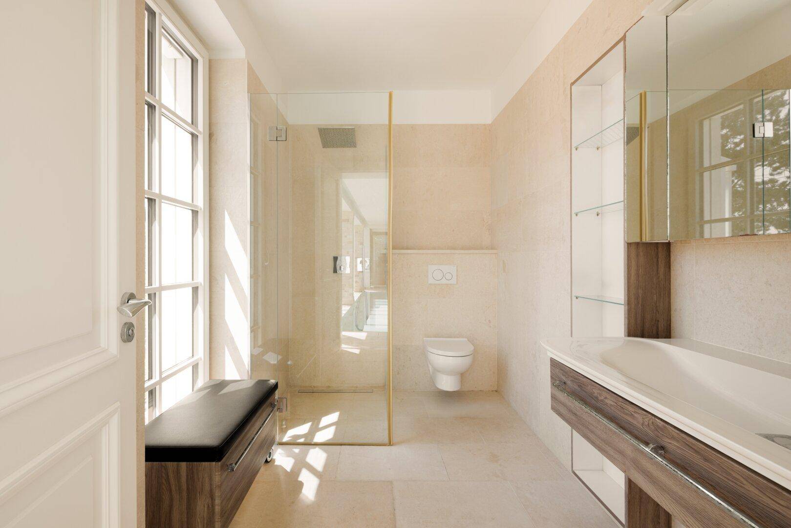Modernes Badezimmer mit begehbarer Dusche, wandhängendem WC und großem Fenster, hell und funktional.