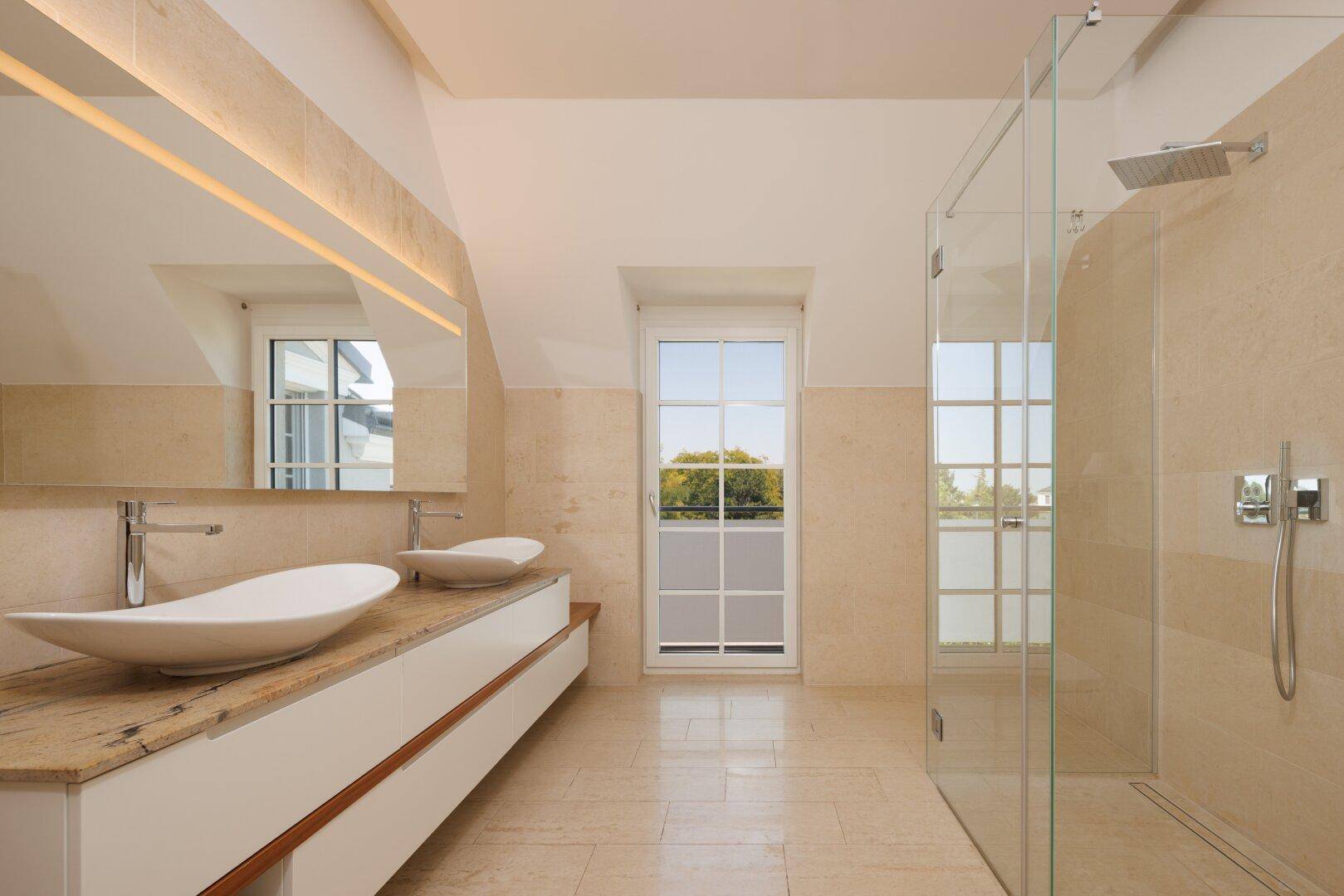 Helles Badezimmer im Dachgeschoss mit Doppelwaschbecken, begehbarer Dusche und großem Fenster, modern und geräumig.