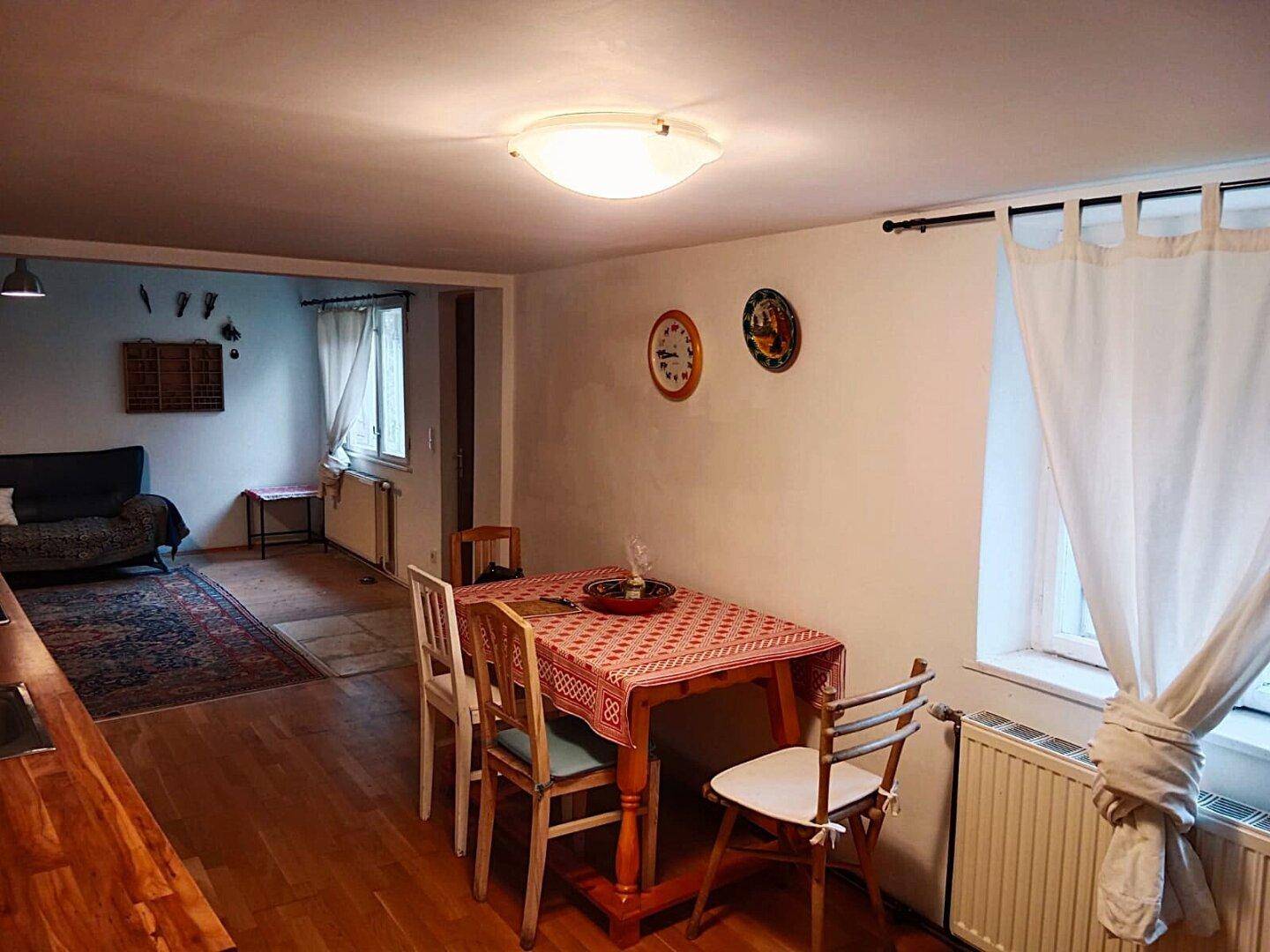 Gemütlicher Essbereich mit Holztisch und Stühlen, offen zum Wohnzimmer, mit Blick auf den Garten.