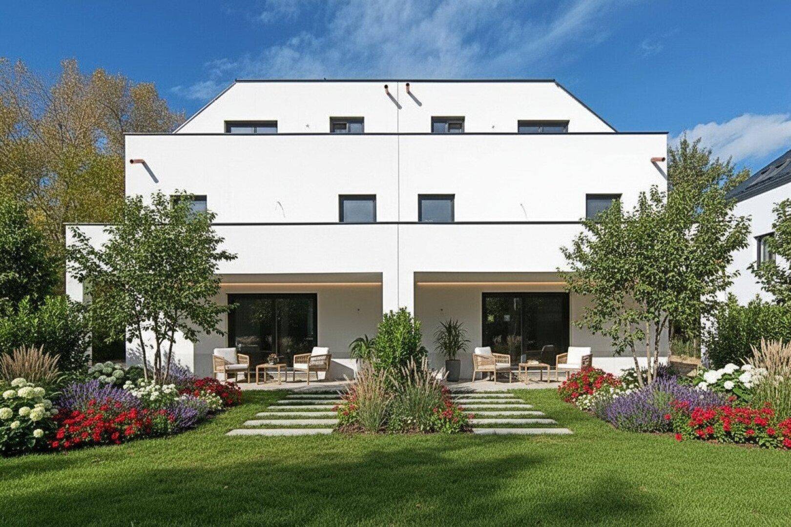 Rückansicht der Häuser mit möblierten Terrassen und einem gepflegten Garten mit Blumenbeeten.