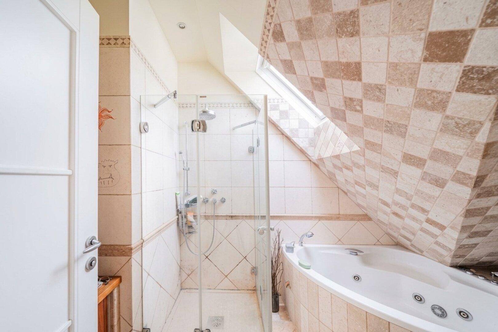 Modernes Badezimmer mit Duschkabine, Eckbadewanne und Dachfenster in der schrägen Decke.