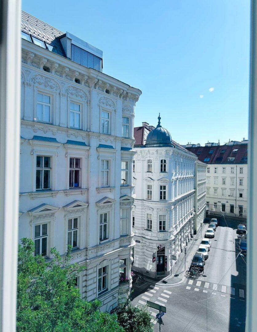 Panoramablick aus dem Fenster auf die belebte Stadtstraße und die umliegenden historischen Gebäude.