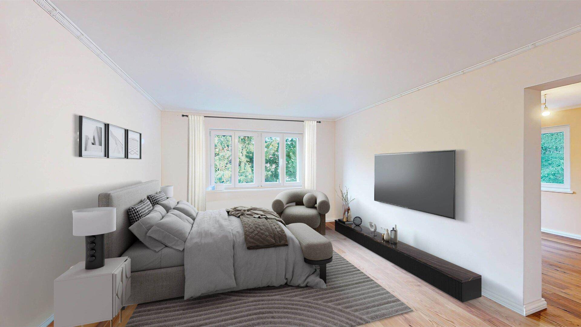 Gemütliches Schlafzimmer mit Doppelbett, Fernseher und Blick ins Grüne durch die Fenster.
