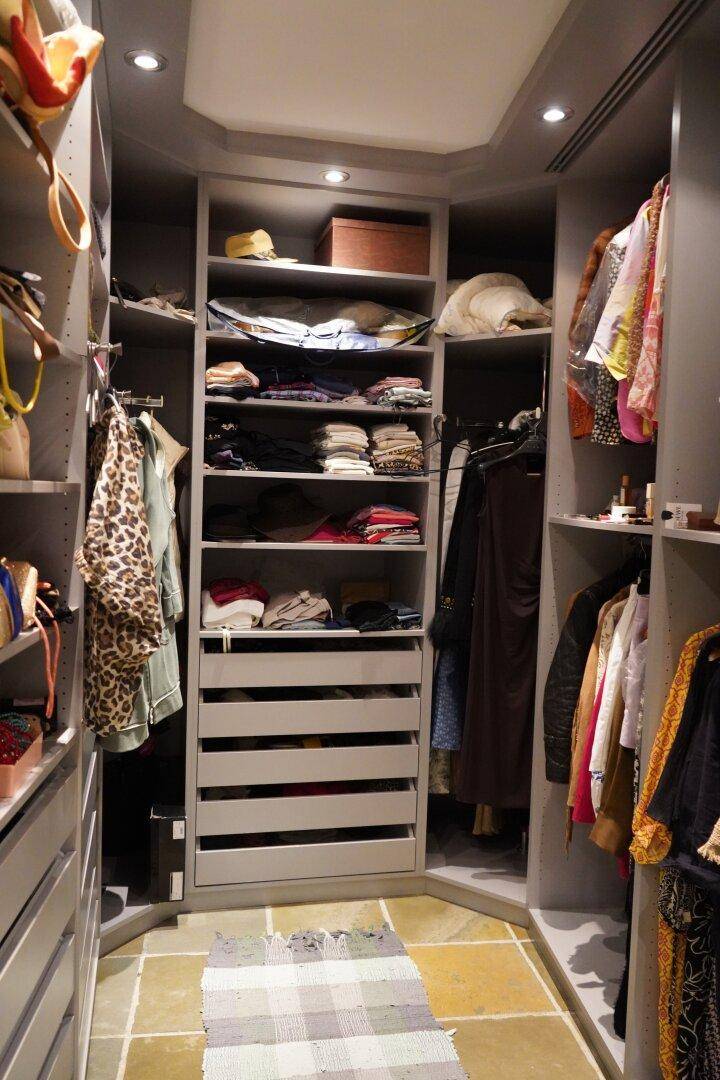 Begehbarer Kleiderschrank mit vielen Regalen, Schubladen und Hängemöglichkeiten für Kleidung.