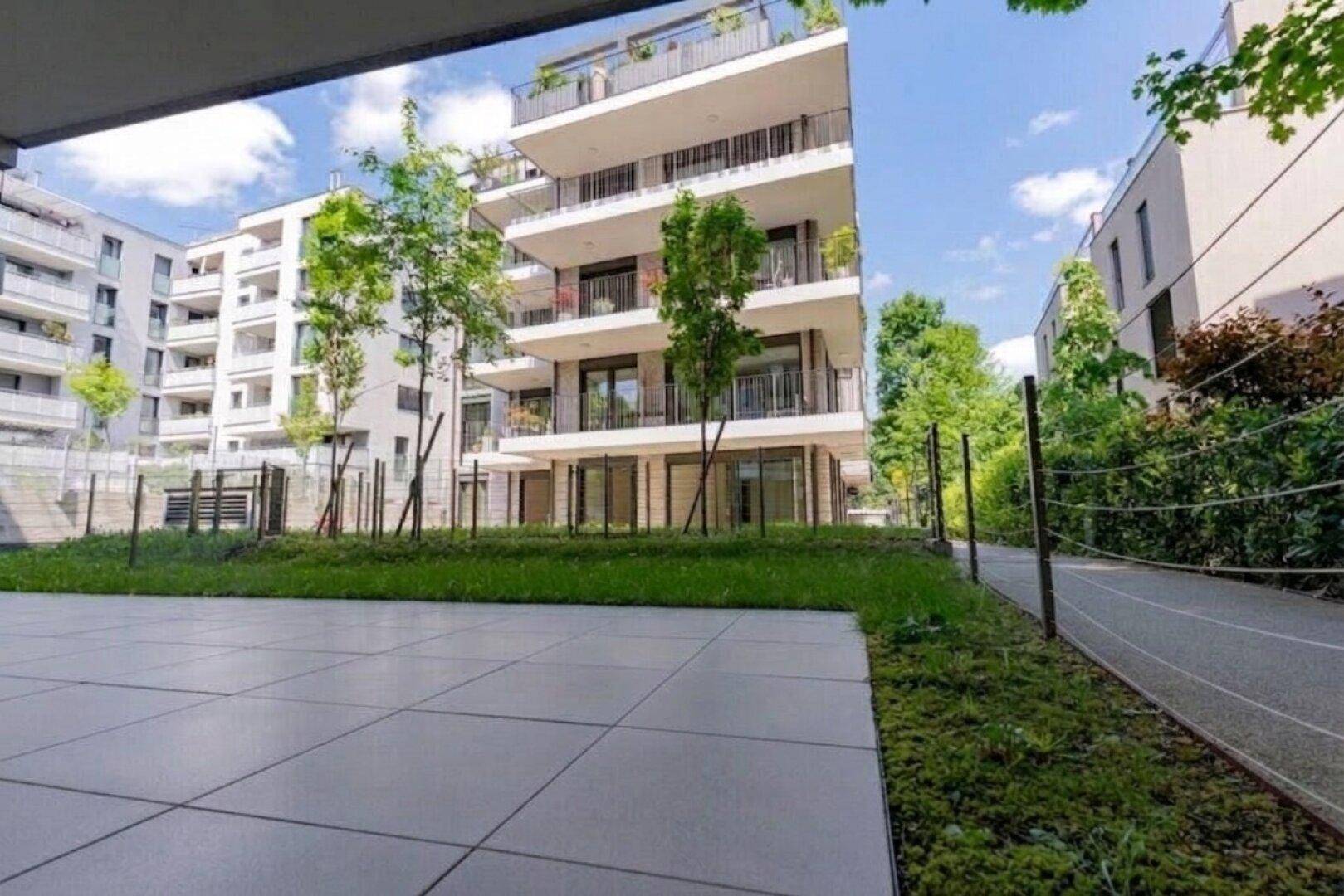 Weitläufige Ansicht eines modernen Wohngebäudes mit Balkonen und gepflegten Außenanlagen.