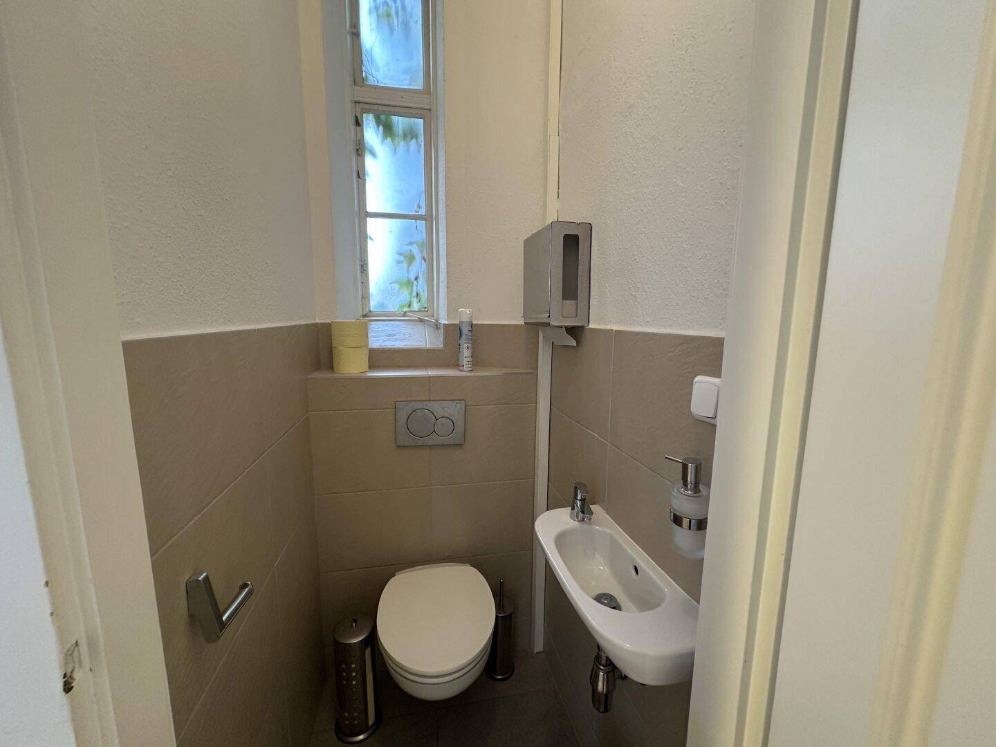 Kleines Gäste-WC mit Wand-WC, Bidet und Fenster für natürliche Belüftung.