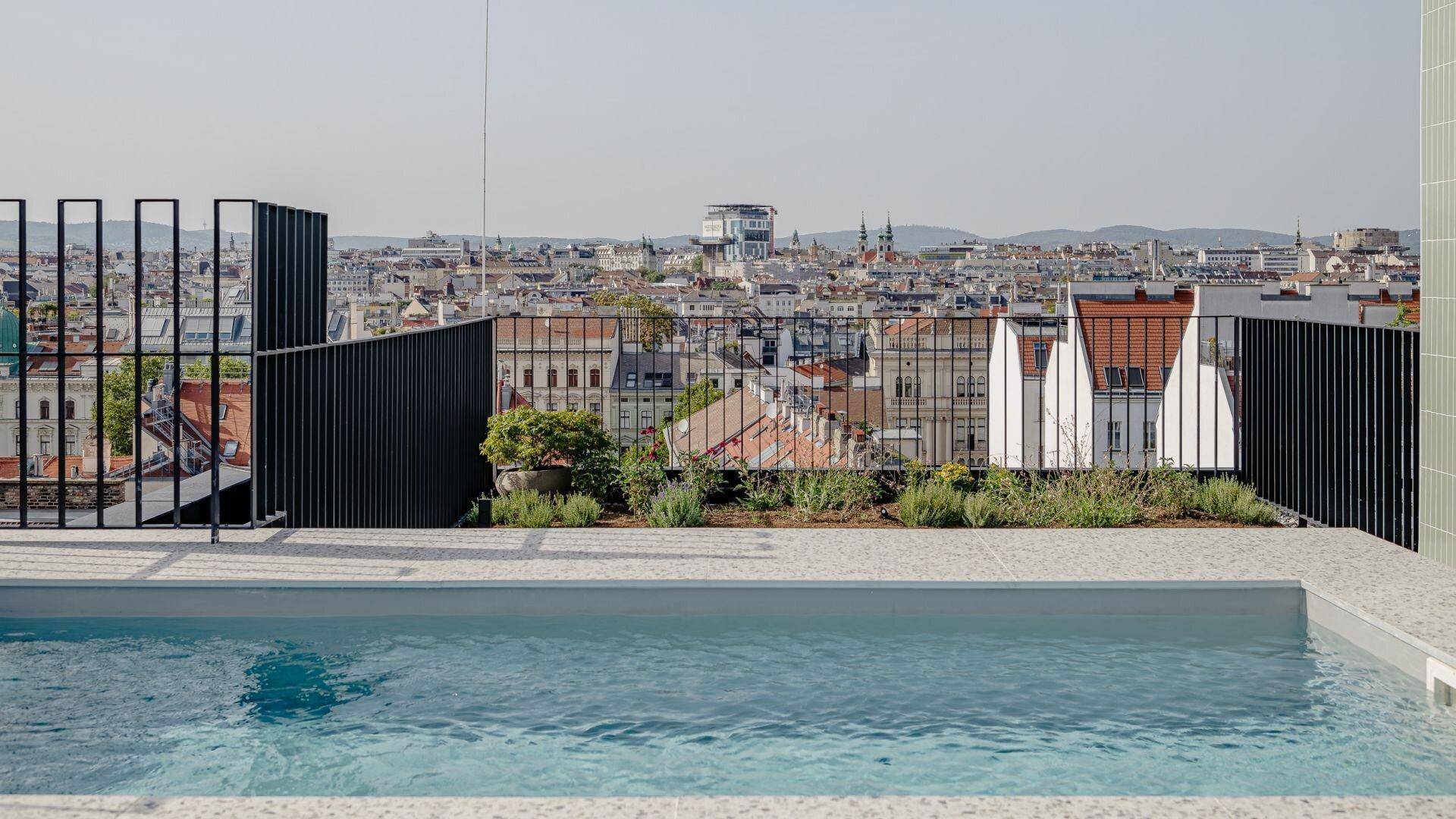 Dachterrasse mit Pool und weitem Blick über die Dächer der Stadt.