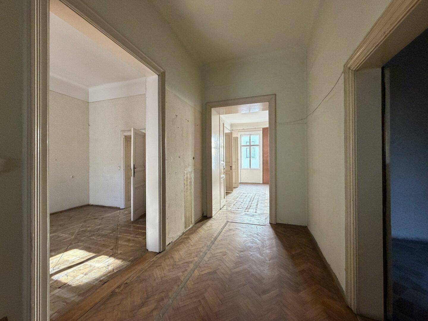 Geräumiger Flur mit Parkettboden und Blick in angrenzende, helle Zimmer.
