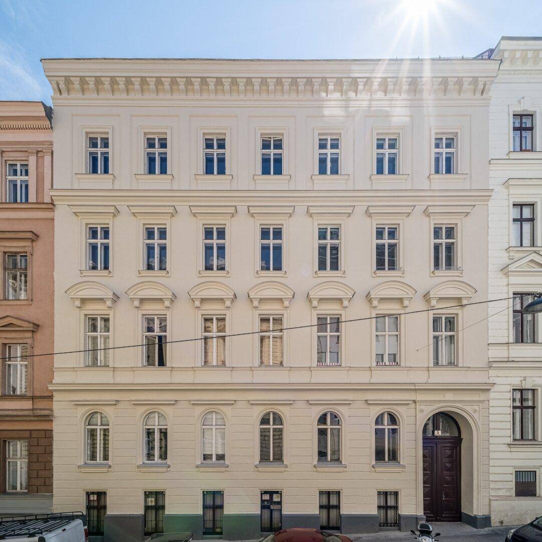 Klassische Altbaufassade mit vielen Fenstern und einem eleganten Eingangsbereich.