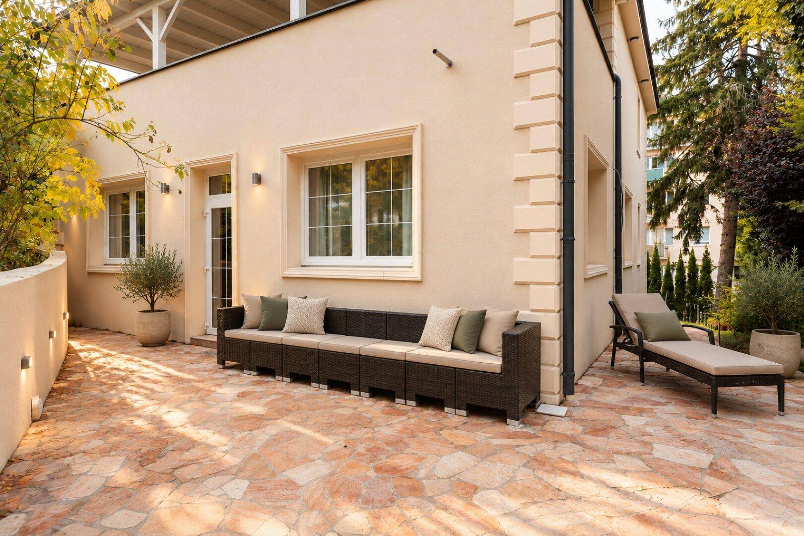 Gemütlicher Außenbereich mit Lounge-Sofa und Liegestuhl, ideal zum Entspannen.