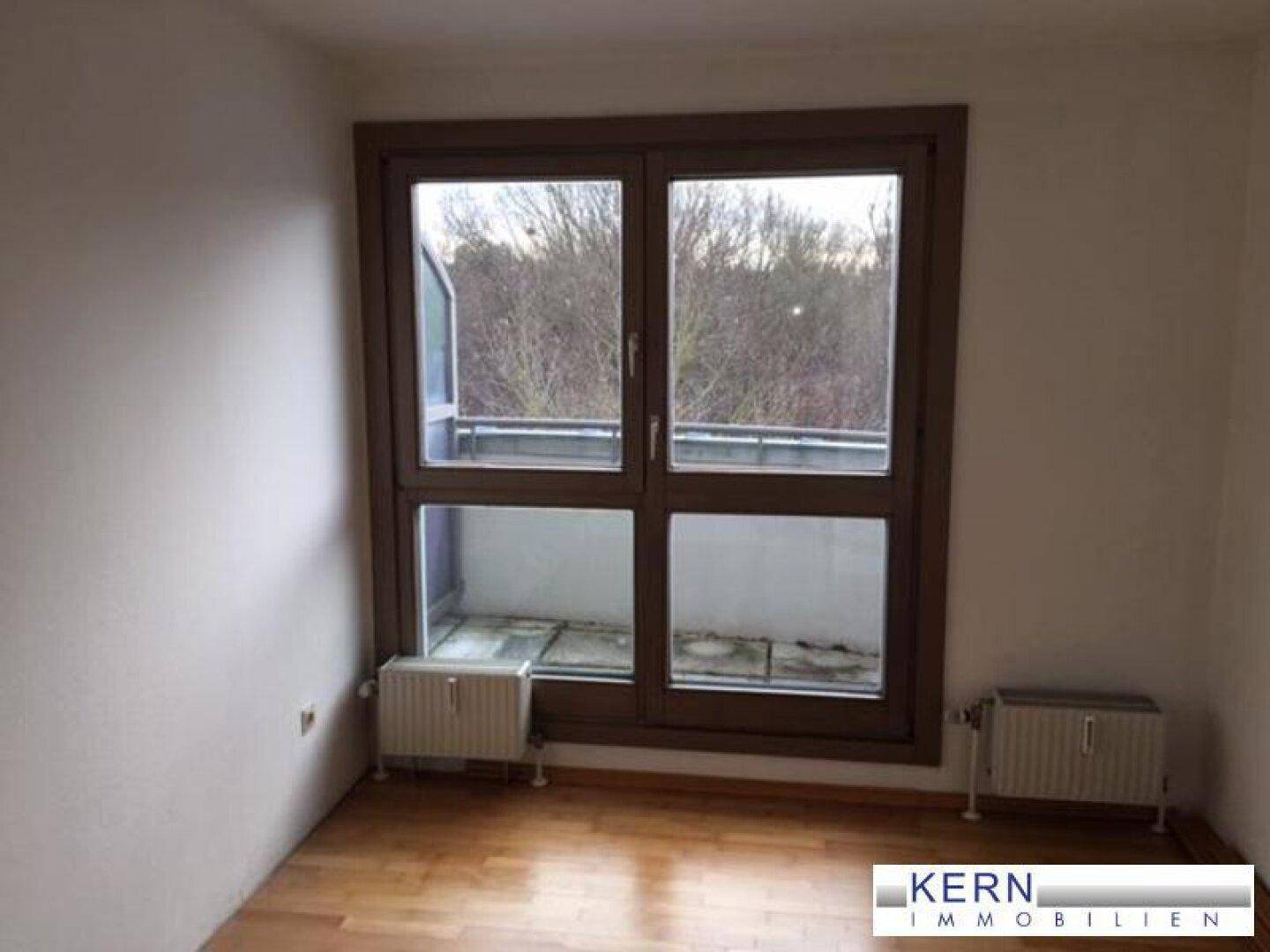 Zimmer mit großem Fenster und Blick ins Grüne, bietet viel Tageslicht und frische Luft.