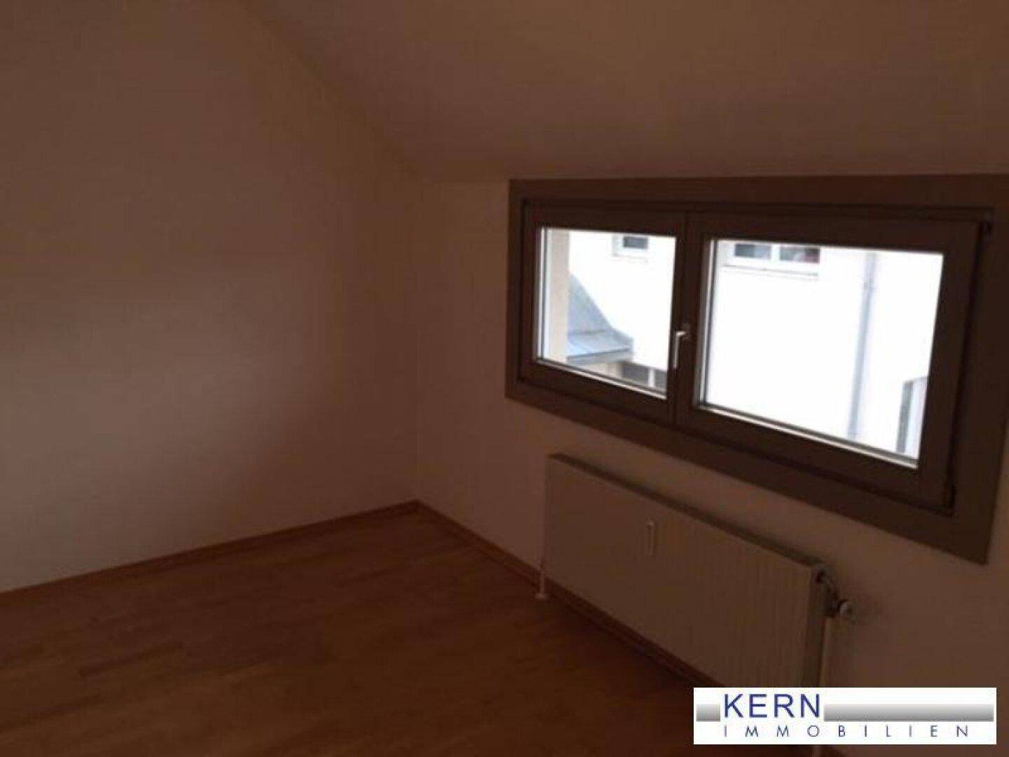 Ruhiges Zimmer mit Fenster und Holzboden, ideal als Schlaf- oder Arbeitszimmer nutzbar.