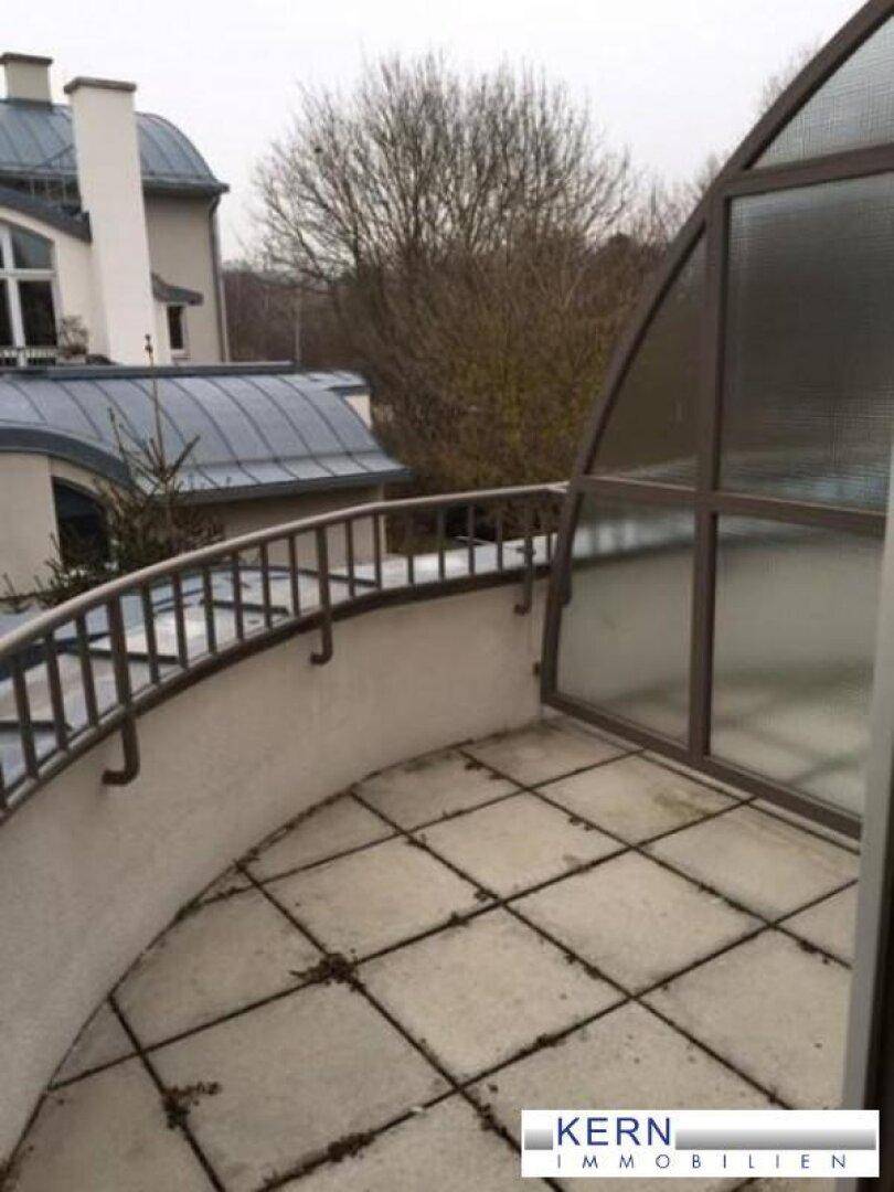 Geschwungener Balkon mit Fliesenboden und Metallgeländer, bietet einen Blick auf die Umgebung.