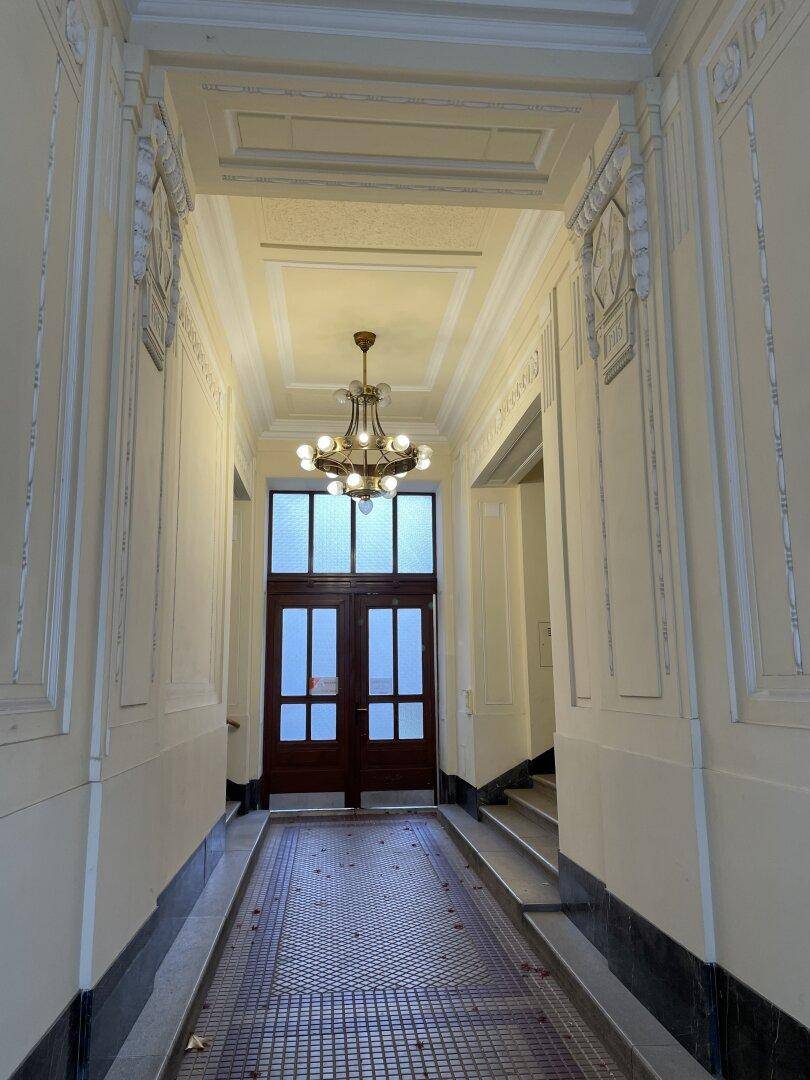 Repräsentativer Eingangsbereich mit Kronleuchter, Stuckdecke und gemustertem Fliesenboden.