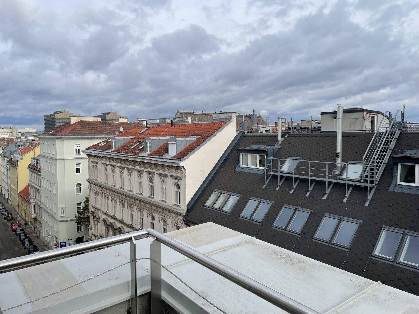 Panoramablick über die Dächer der Stadt mit historischen Gebäuden und modernen Dachkonstruktionen.
