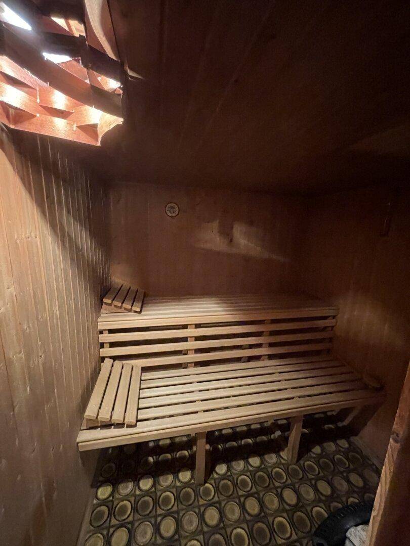 Gemütliche Holzsauna im Kellerbereich mit Sitzbänken und traditionellem Design.
