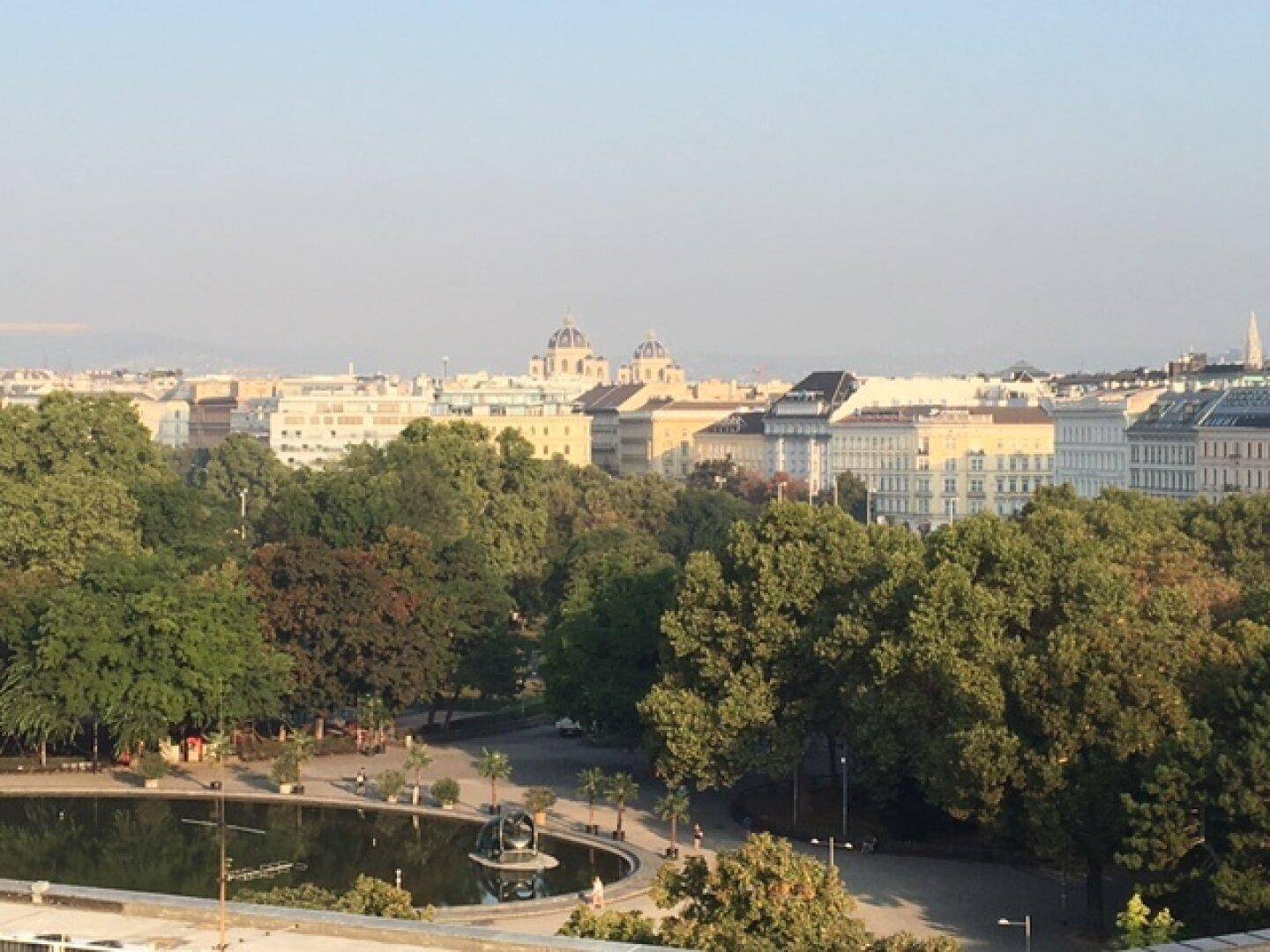 Panoramablick über die Stadt mit viel Grün und einem Park im Vordergrund.