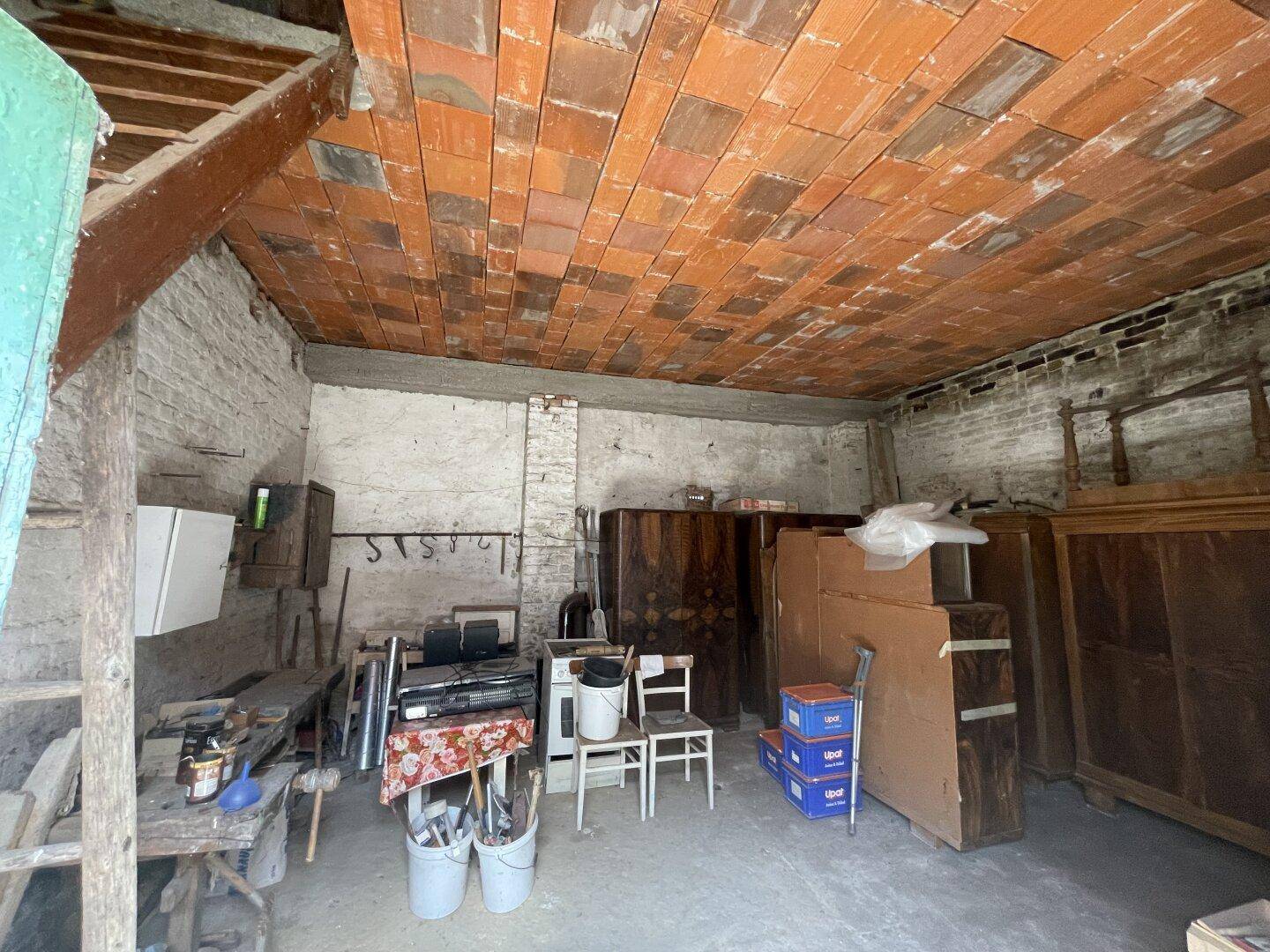 Geräumiger Dachboden oder Abstellraum mit sichtbaren Ziegeln und Holzbalken.