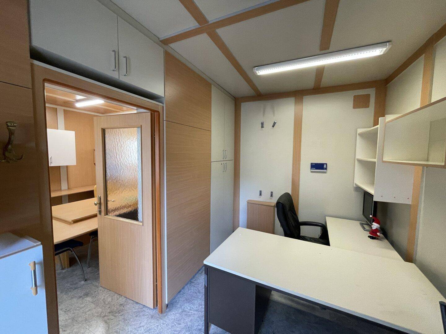 Funktionales Büro mit Schreibtisch, Bürostuhl und integrierten Schränken, bietet effizienten Arbeitsplatz.