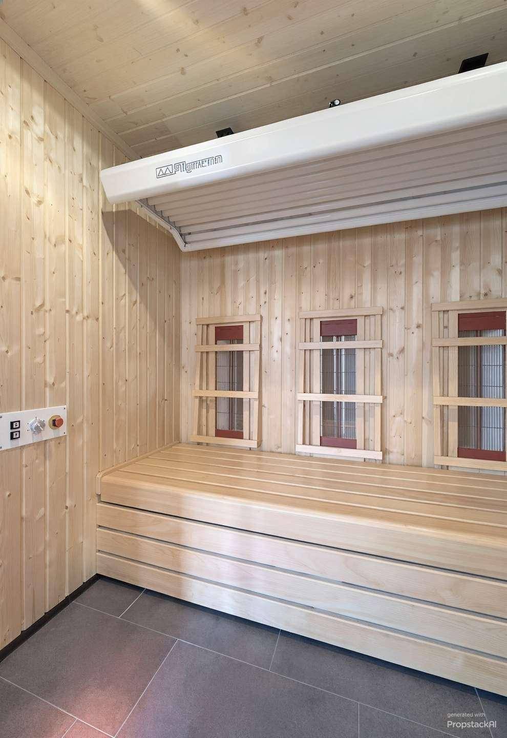 Innenansicht der Sauna mit Holzsitzbänken und Infrarot-Heizelementen für Entspannung.