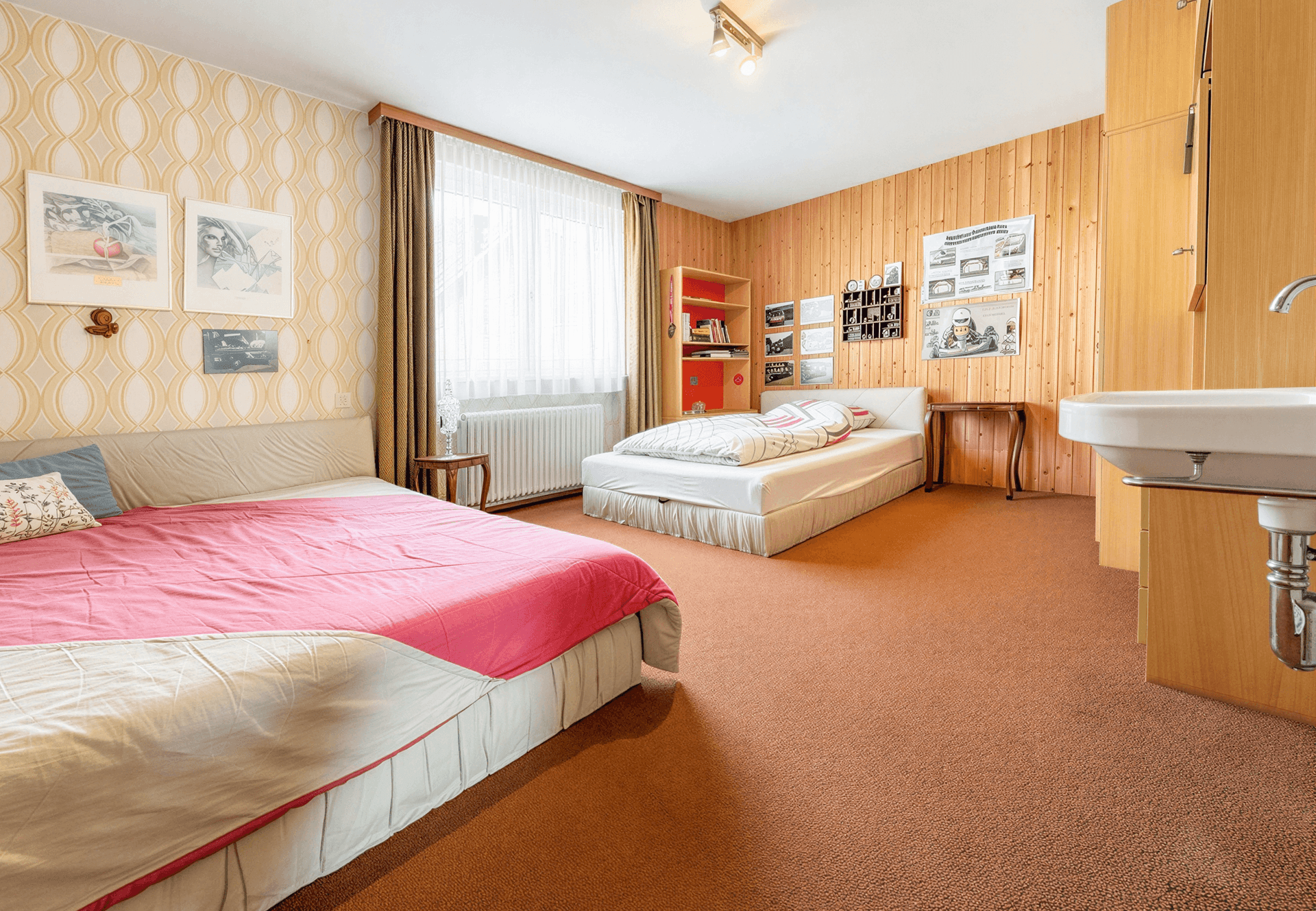 Helles Schlafzimmer mit Holzvertäfelung, zwei Betten und Teppichboden, ideal als Gästezimmer.