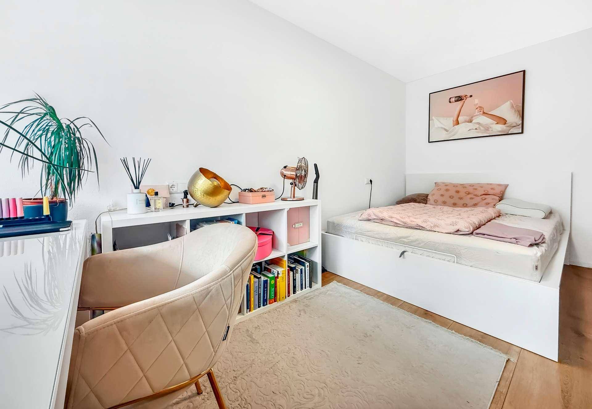 Helles Schlafzimmer mit Bett, Schreibtisch und Regal, modern und funktional eingerichtet.
